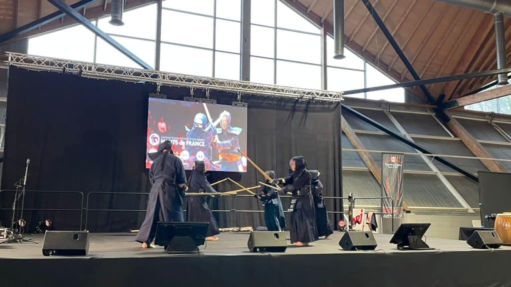 Sabreur médiéval cosplay combat samouraï scène intérieure scène événement sport de combat spectacle d'arts martiaux traditionnels performance culturelle.