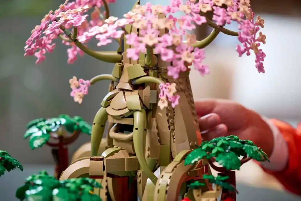 Véritable arbre en briques LEGO avec fleurs roses et feuillage vert, création artistique et design innovant, parfait pour la décoration intérieure ou comme pièce maîtresse pour les amateurs de LEGO.