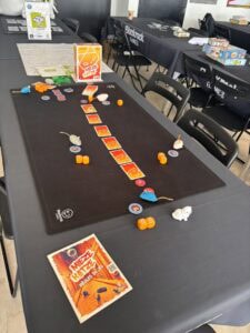 Micro Macro Crimes Jeu de société, jeu de rôle et d'enquête pour famille et amis. Plateau avec figurines, cartes et éléments de jeu colorés pour découvrir des mystères et résoudre des énigmes captivantes.