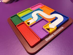 Puzzles connectés de couleurs vibrantes sur une table violette, parfaits pour stimuler la logique et la coopération lors de jeux en famille ou entre amis.