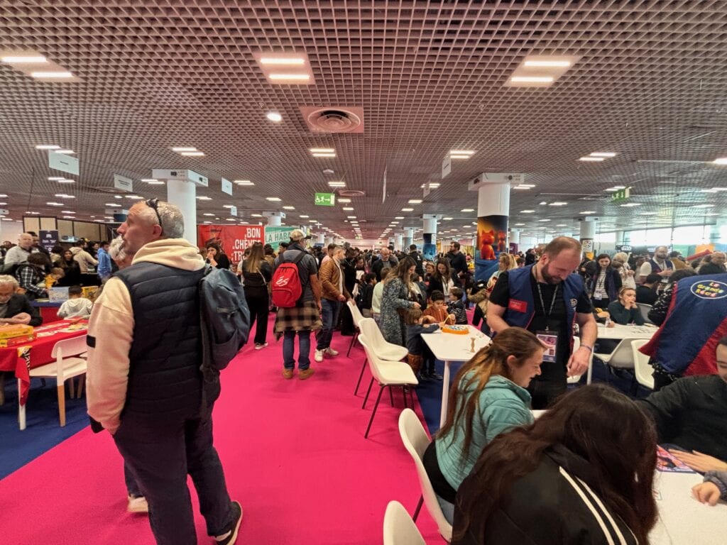 Salle d'événement de gaming Air-Gaming avec de nombreux participants jouant à des jeux vidéo pour tous âges et niveaux, ambiance conviviale et compétitive.
