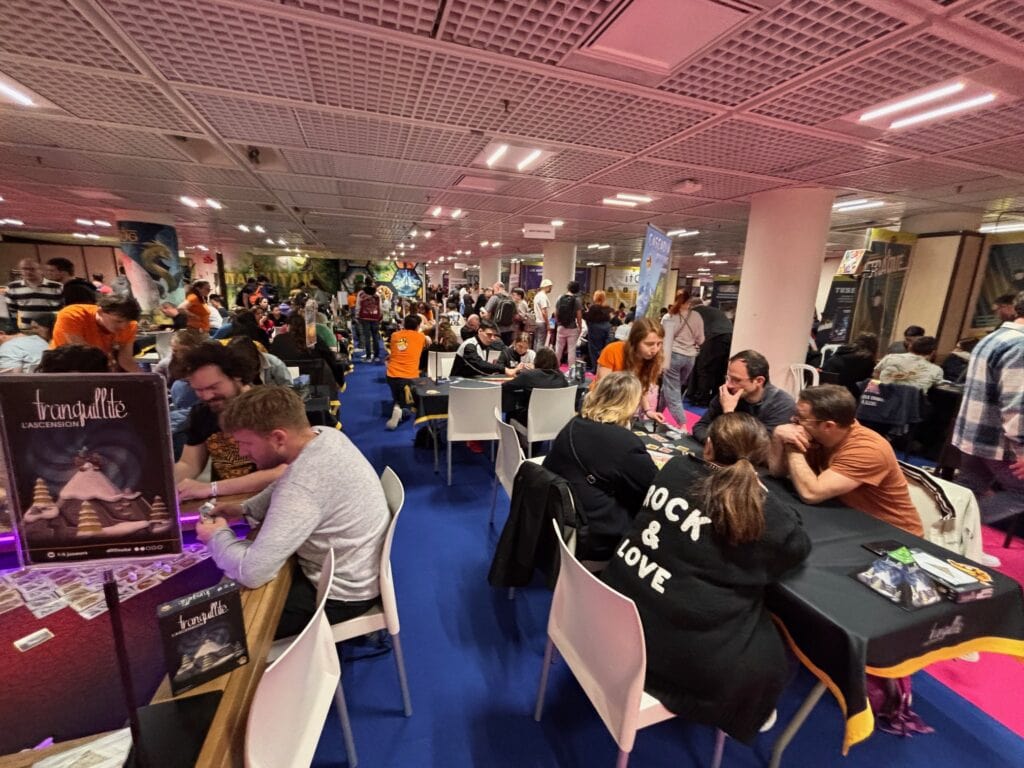 Connection et ambiance lors de l'événement de jeux vidéo Air-Gaming, salle comble avec des joueurs passionnés et des échanges stratégiques dans une atmosphère conviviale.