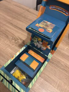 Coffret de jeux Pokémon avec cartes, figurine Pikachu, et accessoires de jeu Pokémon, parfait pour les fans de jeux de cartes et de collections Pokémon.