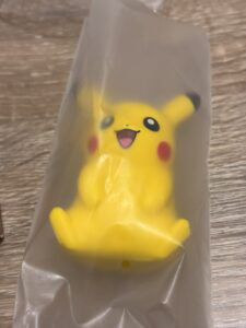 Pikachu en plastique jaune présenté dans un sac transparent, version miniature et décorative, idéale pour les fans de Pokémon et la collecte d'objets liés à l'univers Pokémon.