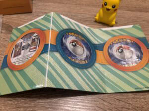 Pokémon TCG booster pack with colorful design, featuring three visible booster packs and Pikachu figurine, perfect for fans of Pokémon trading card game and gaming collectibles.