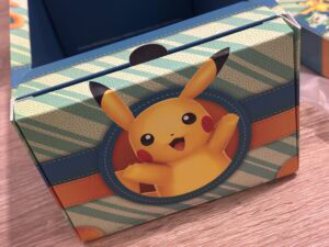 Poche Pokémon Pikachu, emballage coloré avec illustration de Pikachu, thème gaming et collection Pokémon, parfait pour fans et collectionneurs.