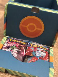 Vaporisateur de cartes Pokémon dans une boîte de collection Pokémon avec un design coloré et détaillé, idéale pour les fans de jeux de cartes Pokémon et de collectionneurs.