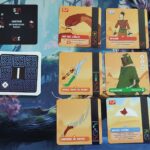 Défenseur de jeu de société avec cartes illustrées et jetons pour le jeu de stratégie dans l'univers d'Air-Gaming, mettant en scène des personnages et des objets liés à l'aventure désertique.