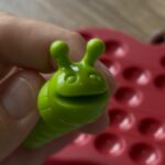 Lutin en forme de chenille verte pour jeu de shopping ou de mouvement, avec plateau de rangement à l'arrière, idéal pour enfants et divertissement éducatif.