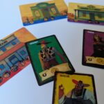 Cartes de jeu de style western et illustrations colorées, incluant un saloon, cowboy, veuve et mineur, jouant à un jeu de société avec des éléments de carte et de plateau.