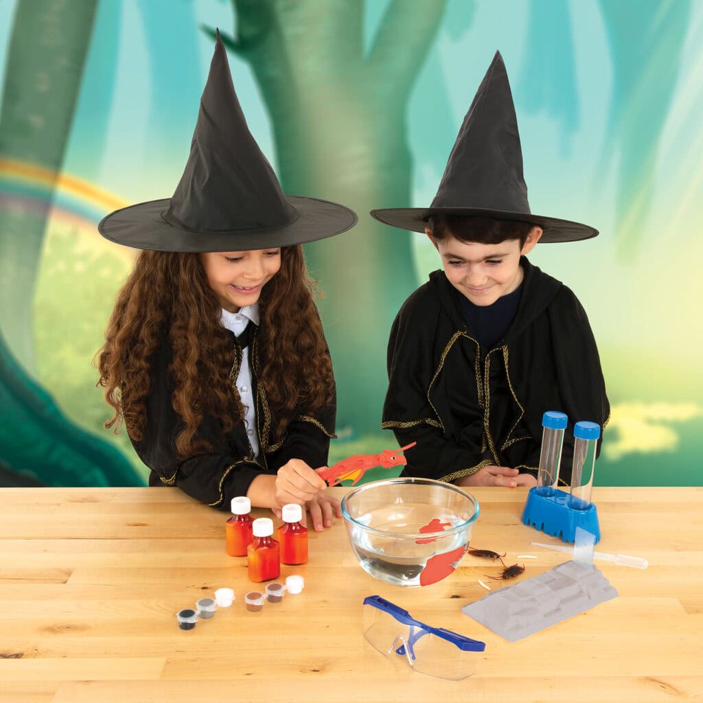 Amusements d'enfants en mode sorcellerie avec des jeunes filles portant des chapeaux de sorcière, expérimentant la science magique et la fabrication de potion dans un décor féerique.