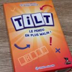 TILT le jeu de société, face avant montrant une boîte orange avec le logo TILT en lettres blanches et bleues, comprenant des flèches et éléments graphiques colorés, idéal pour famille et amis.
