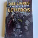 Héros de livres de fantasy avec une armure, un casque de guerrier et une épée dans une scène épique.