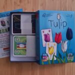 Alt text : Jeu de société Tulip avec cartes colorées illustrant des tulipes, boîte bleue, parfait pour enfants dès 8 ans, 2 à 6 joueurs, moments de jeu en famille ou entre amis.