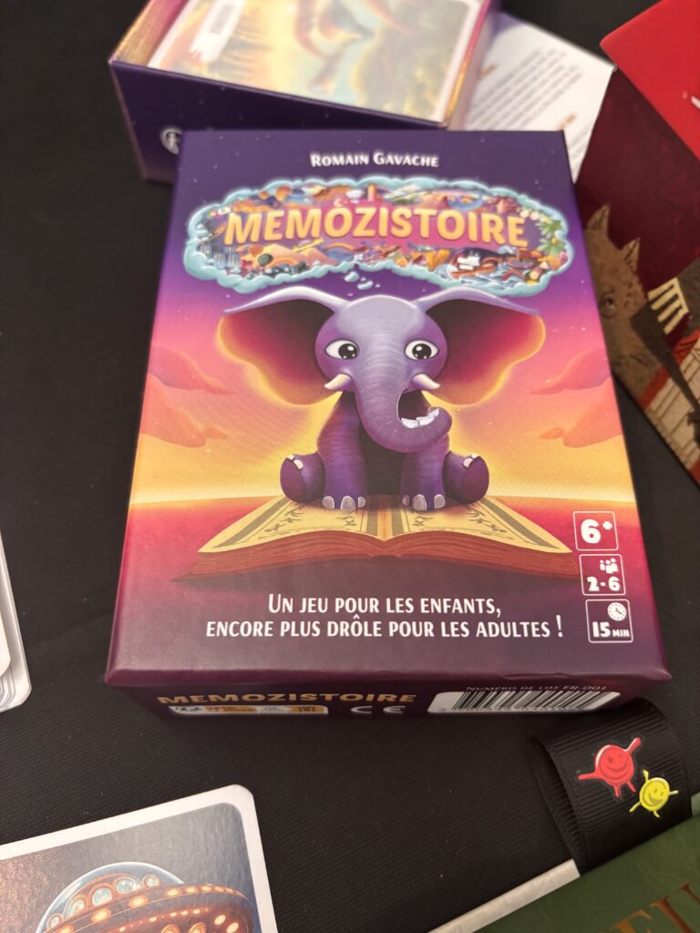 Éléphant en cartoon rose et violet jouant avec un livre enchanté, illustration colorée et attrayante, représentant un jeu de société pour enfants, parfait pour la famille et le divertissement ludique.