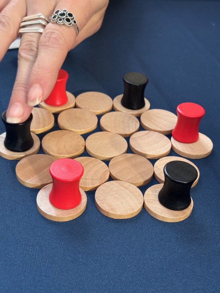 Jeu de dames en bois avec pions rouges et noirs sur une table bleu foncé, idéal pour les jeux de société et la stratégie.