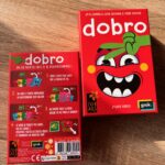 Jeu Dobro, jeu de cartes familial, coloré et ludique avec illustrations drôles, parfait pour jouer en famille ou entre amis, idéal pour tester ses compétences en calcul et stratégie.