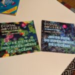 Livres de jeux de société "Digital Abysses" pour enfants, sur le thème de l'océan, mêlant super-héros et aventure numérique, idéal pour stimuler l'imagination et la réflexion des jeunes joueurs.