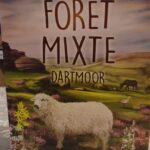 Joueur indépendant, jeu de société pour familles et amateurs de jeux de stratégie, se déroulant dans un paysage de Dartmoor avec moutons et nature sauvage.
