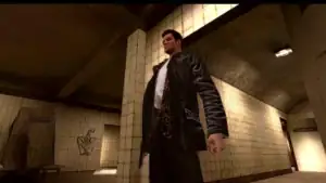 Un homme debout dans un métro ou un tunnel, portant un manteau en cuir noir et un foulard léopard, dans un environnement urbain sombre avec des murs en céramique beige.