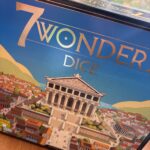 2. Boîte de jeu Wonder Dice avec illustration d'une ville antique et d'un temple grec, parfait pour les amateurs de jeux de société et d’aventures historiques.