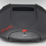 Console Atari Jaguar, console de jeux vidéo rétro classique avec design noir, logo rouge et boutons, pour gaming nostalgique et collectionneurs, pièce de collection de consoles vintage.