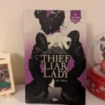 Couverture du roman "Theft Liar Lady" présentant une femme en silhouette avec peel noir et violet, évoquant suspense et intrigues.