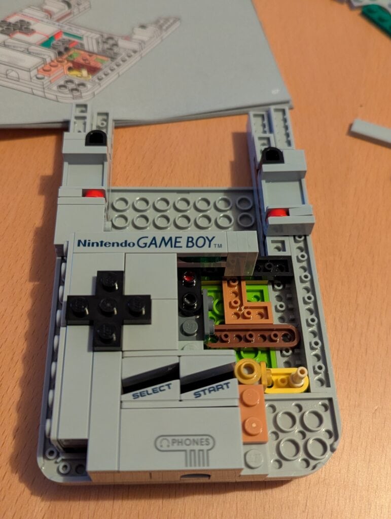 Puce Game Boy en Lego colorée, construction de console de jeux vidéo vintage avec boutons "Select" et "Start" pour une expérience nostalgique, perfect pour les fans de jeux vidéo classiques et de modélisme créatif.