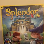 Une image du jeu de société Splendor Kids, destiné aux enfants, avec des personnages ludiques et un décor de château magique.