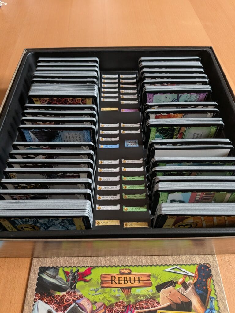 2. Pile de cartes du jeu de société Dominion illustrant les différentes extensions et ressources, parfait pour la stratégie et la collection de jeux de société.