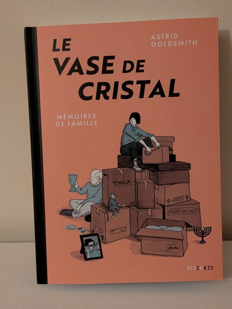 Vase de cristal, illustration de Astrid Goldsmith, avec des boîtes empilées et des objets personnels, évoquant la mémoire et la famille.