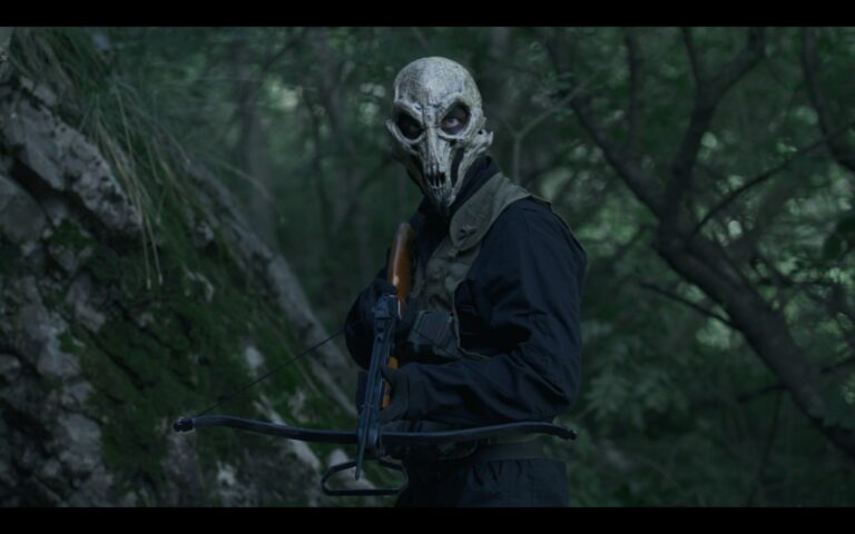 Un personnage mystérieux portant un masque de squelette dans une forêt dense, équipé d’un arc et de flèches, évoquant un univers de jeu vidéo ou de film d’action.