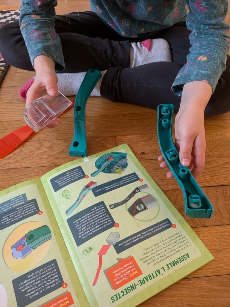 Jeu éducatif pour enfants avec outils d'observation d'insectes, comprenant un guide illustré et un kit d'observation pour découvrir la nature.