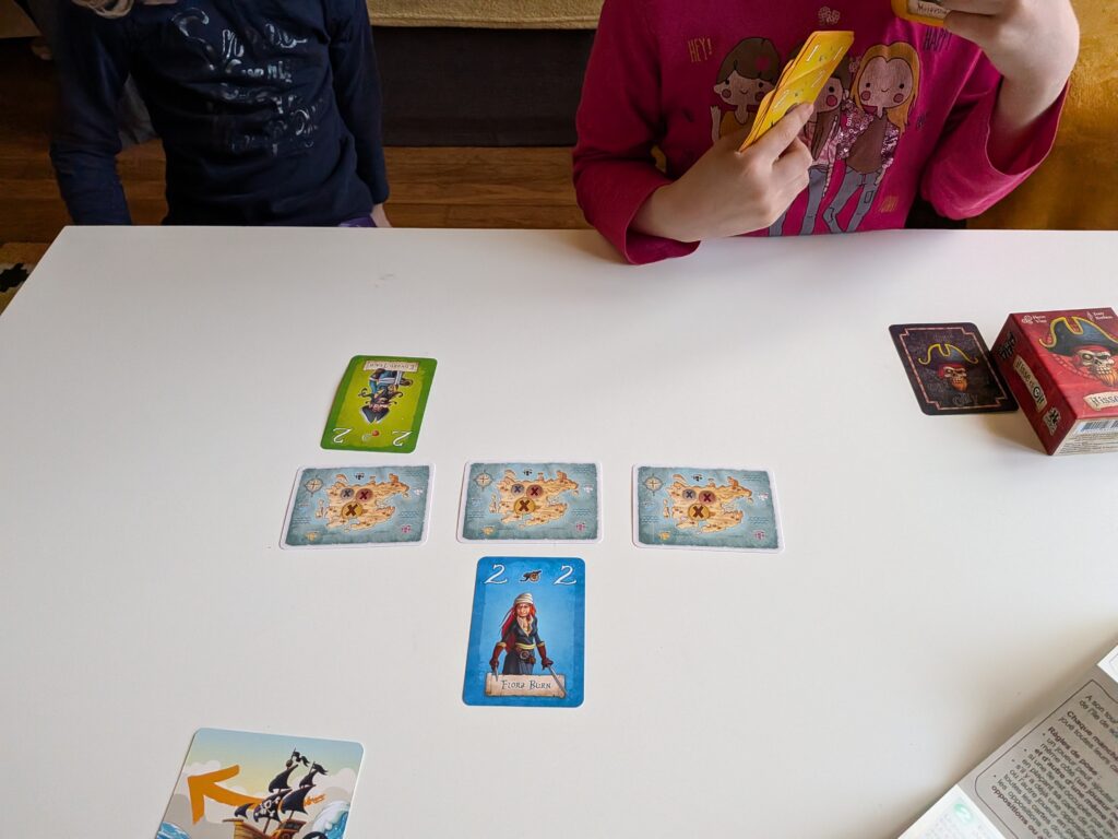 Jeu de société "Hisse et Oh" pour enfants, avec cartes illustrées et figurines colorées, favorisant la coordination et la stratégie lors de parties amusantes.