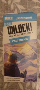 Jeu de société Unlock! L’Ascension, aventure courte inspirée des escape rooms, avec illustration d’un explorateur face à une montagne enneigée, idéal pour les amateurs d’énigmes et d’aventure.