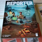 Dossier de jeu vidéo "Reporter" avec dauphin, illustrant un jeu d'enquête et d'aventure sous-marine, avec des journalistes et un environnement aquatique.