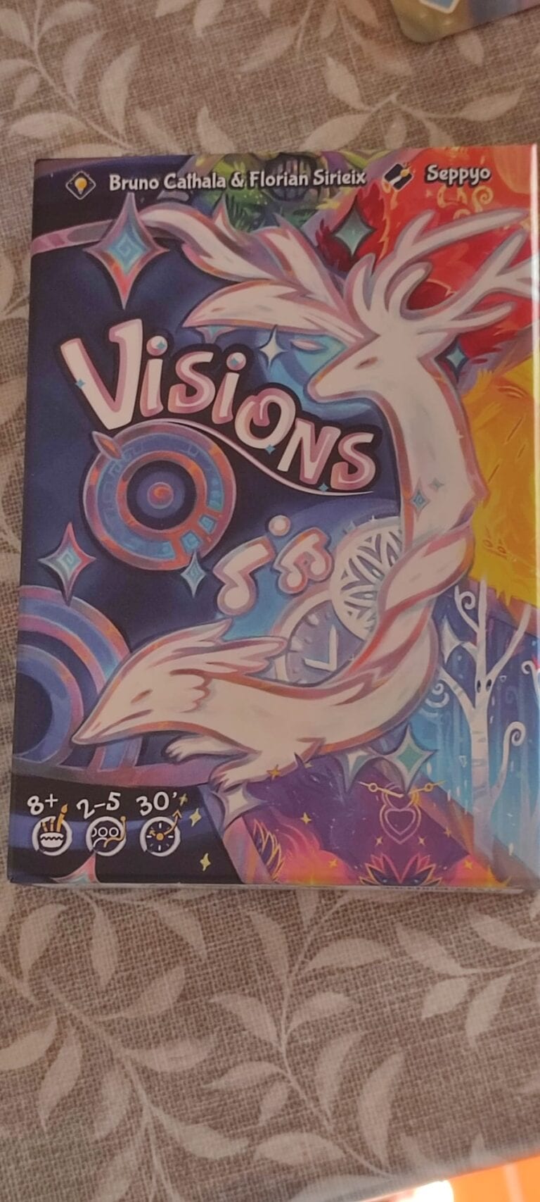 Jeu de société Visions pour enfants et familles, mettant en scène un cerf magique et des éléments fantastiques, idéal pour les joueurs de 8 ans et plus.