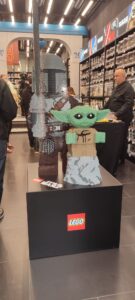 Figurine LEGO Baby Yoda (Grogu) exposée dans un magasin Air-Gaming, mettant en valeur la collection de jouets et accessoires de jeux vidéo.
