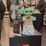Figurine LEGO Baby Yoda (Grogu) exposée dans un magasin Air-Gaming, mettant en valeur la collection de jouets et accessoires de jeux vidéo.