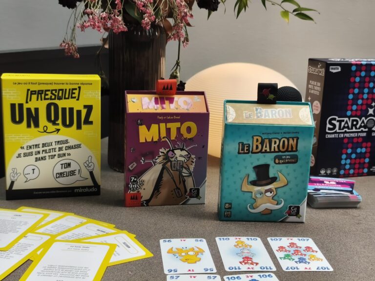 Jeux de société et cartes pour enfants et adultes sur une table, incluant quiz, personnages de manga et jeux de stratégie.
