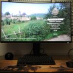 Écran d'ordinateur affichant un menu de paramètres en français, avec un paysage rural en arrière-plan.