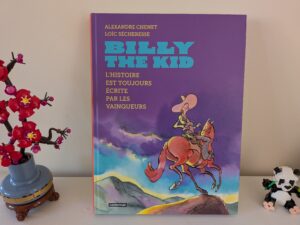 Couverture du livre 'Billy the Kid' illustrée avec un cow-boy à cheval, couleurs vives et titre en bleu sur fond violet.