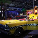 Taxi jaune de Crazy Taxi exposé à Gamescom 2026 avec décor coloré et ambiance animée.