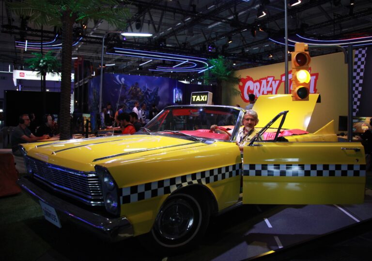 Taxi jaune de Crazy Taxi exposé à Gamescom 2026 avec décor coloré et ambiance animée.