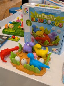 Jeu de société pour enfants avec figurines de diplodocus colorés et œufs en plastique, idéal pour stimuler la créativité et la logique des jeunes.