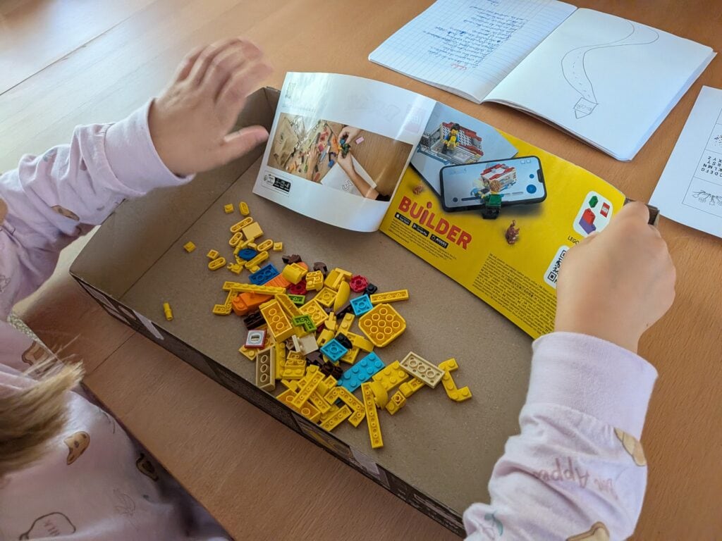 Enfant construisant avec des LEGO Pokémon Pikachu et la cabane d’entraînement, accessoires colorés et instructions de montage.