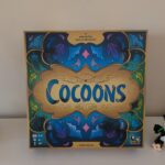 Jeu de société Cocoons avec design coloré et motifs floraux, idéal pour 2 à 4 joueurs, à partir de 8 ans, publié par Camélia Chassagne.