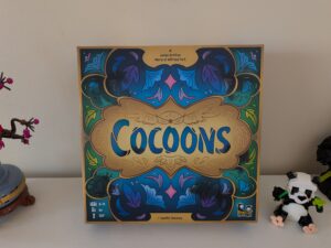 Jeu de société Cocoons avec design coloré et motifs floraux, idéal pour 2 à 4 joueurs, à partir de 8 ans, publié par Camélia Chassagne.