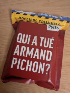 Livre de poche sur le mystère de la mort d'Armand Pichon, dans la série Dossiers Criminels Pocket, posé sur une table en bois.