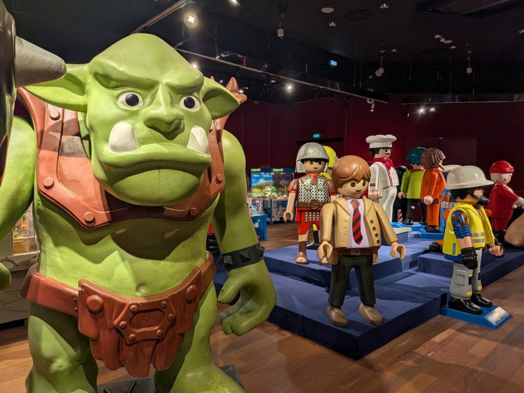 Exposition éphémère de figurines Playmobil avec personnages variés et décorations colorées à Drouot.